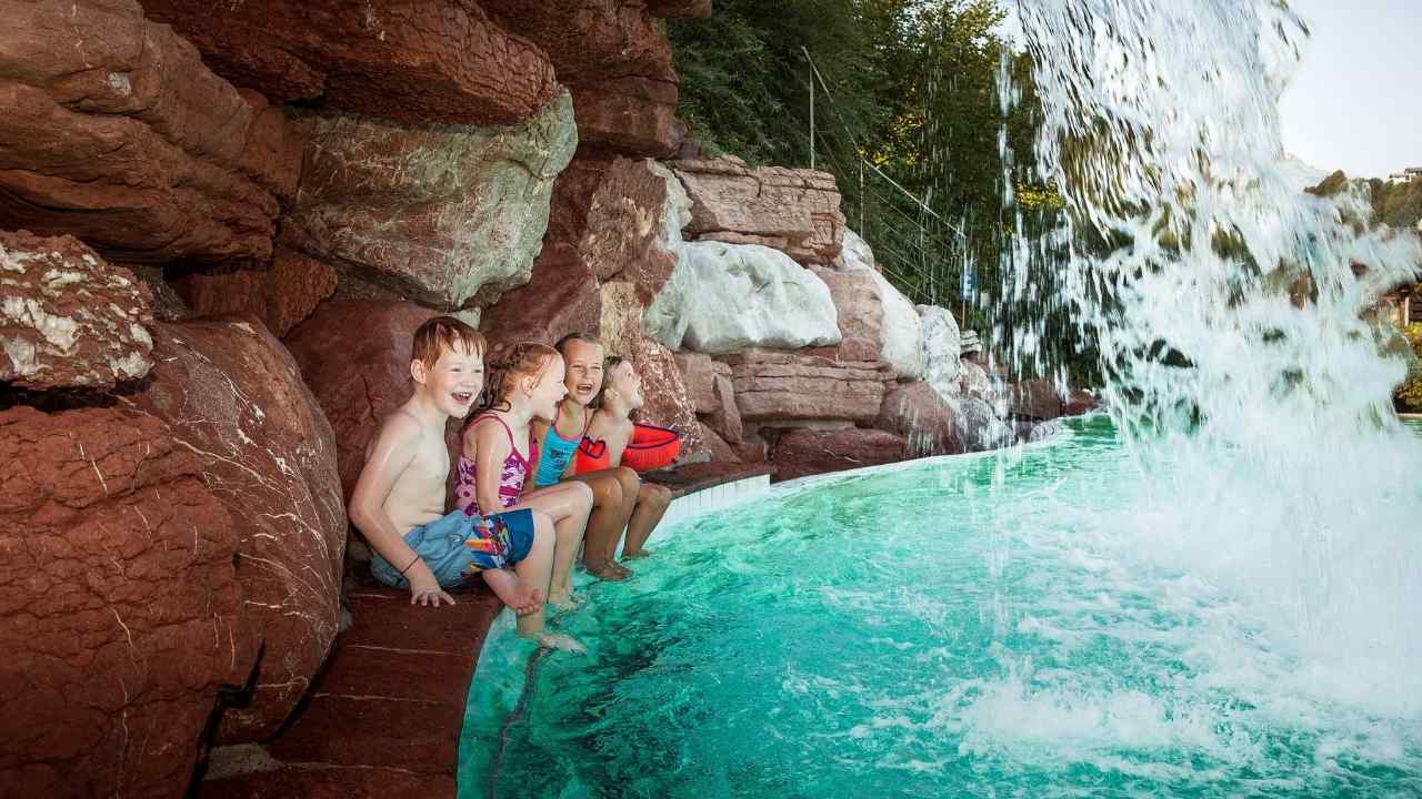 Watzmanntherme Solebecken außen und Kinder sitzen unter dem Wasserfall